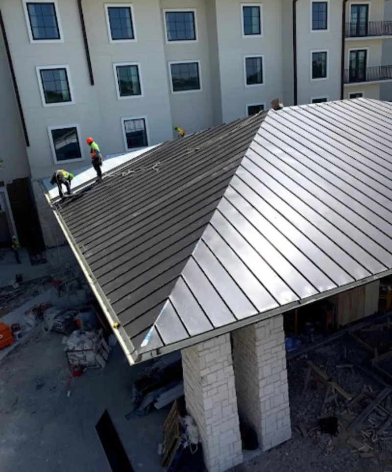 Crew installing standing seam metal roof panels on a commercial project in Fort Valley